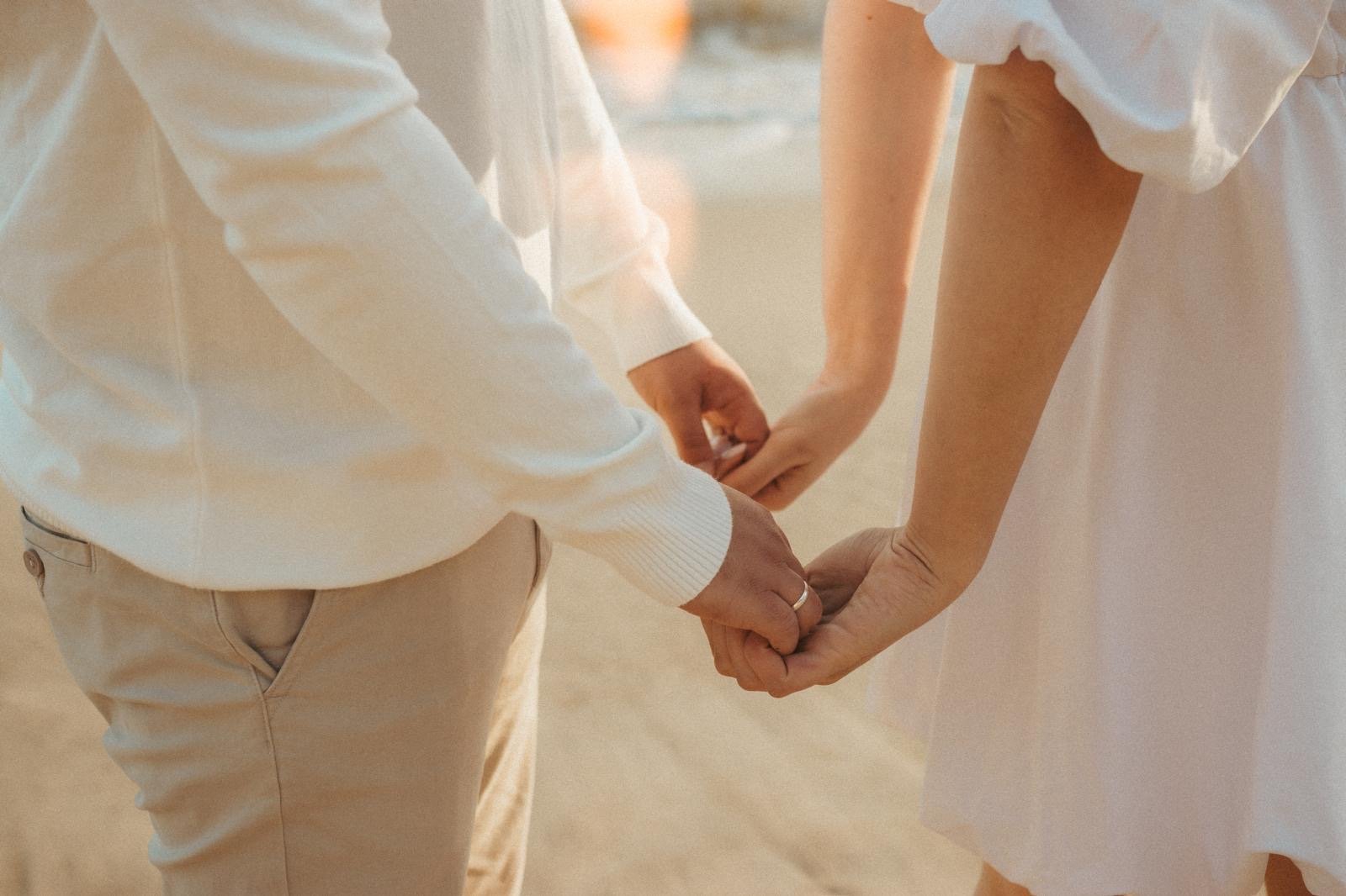 Casal de mãos dadas na praia